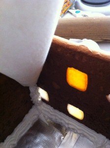 pipe royal icing along base and up sides of the gingerbread house